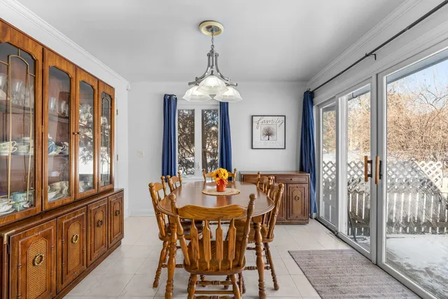 a dining room with furniture a chandelier and wooden floor