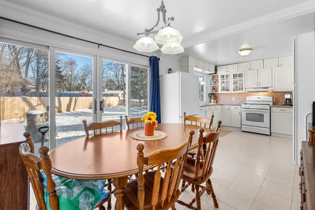a kitchen with stainless steel appliances granite countertop a stove top oven a dining table and chairs