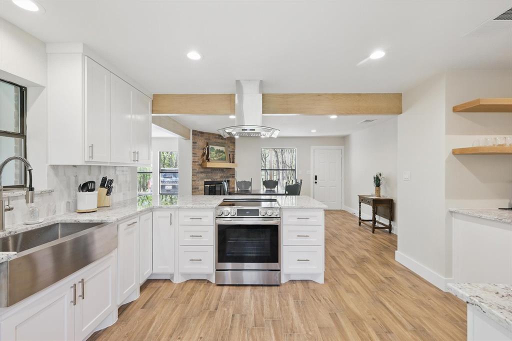 2446 Neely Trail Valley View, TX 76272 - Photo 5 of 29 a kitchen with stainless steel appliances granite countertop a sink cabinets and wooden floor