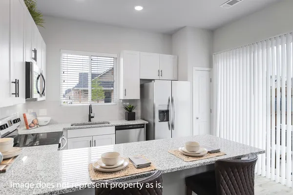 a kitchen with stainless steel appliances granite countertop a sink a stove a refrigerator and cabinets