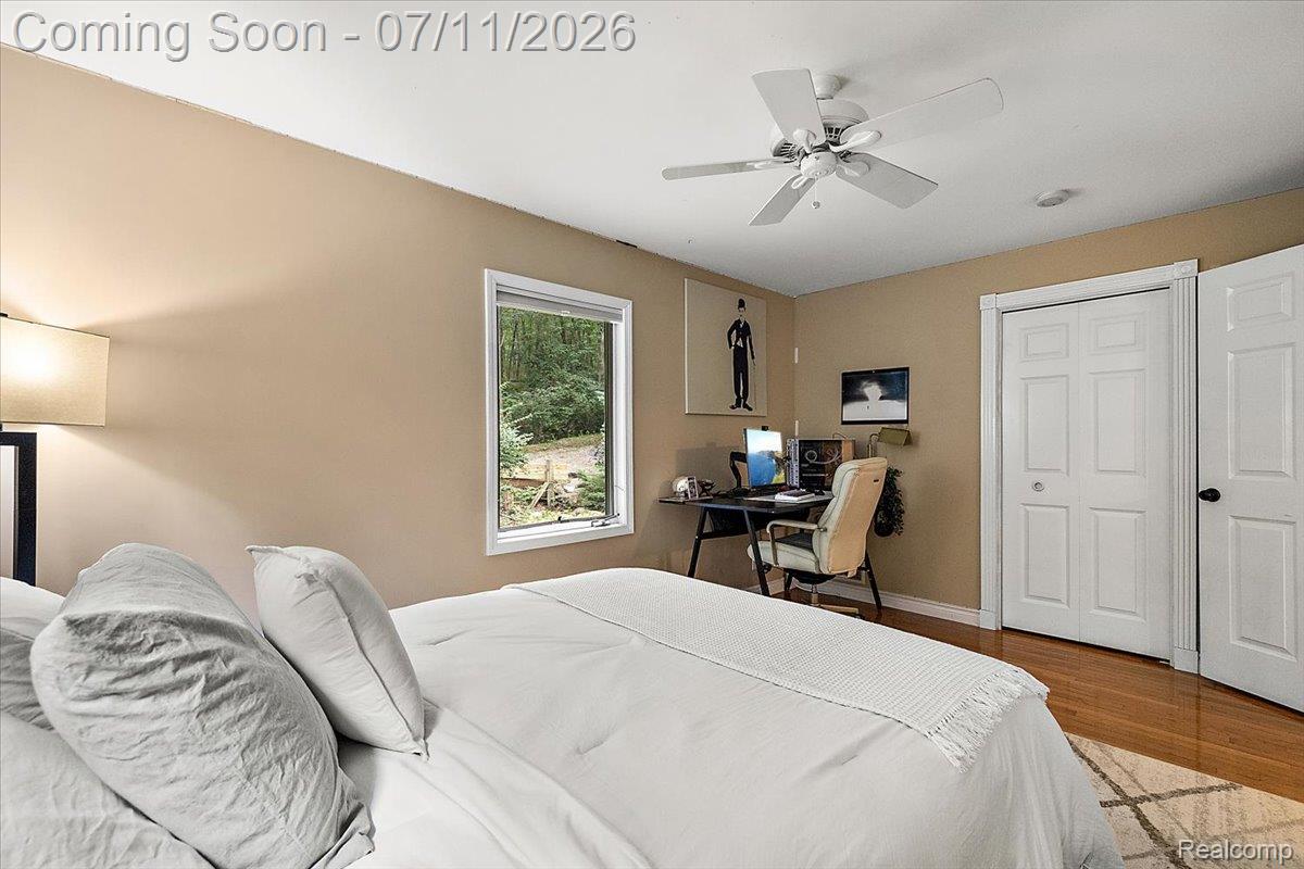 4219 Gardner Road Metamora, MI 48455 - Photo 34 of 87 Bedroom featuring hardwood flooring, a ceiling fan, and a window with wooded surroundings