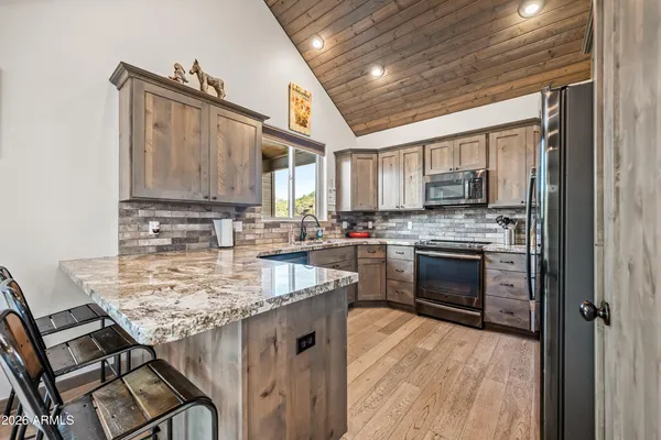 a kitchen with stainless steel appliances granite countertop a sink stove and cabinets