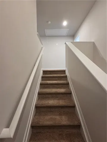 a view of a livingroom with wooden floor and a refrigerator