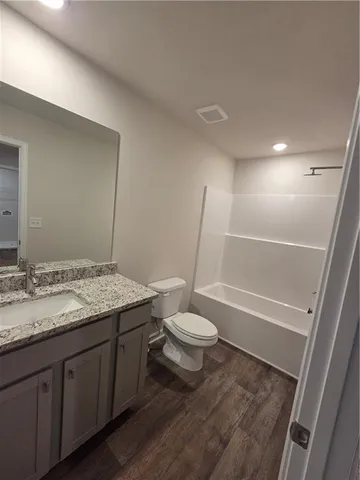 a bathroom with a granite countertop toilet sink and a mirror