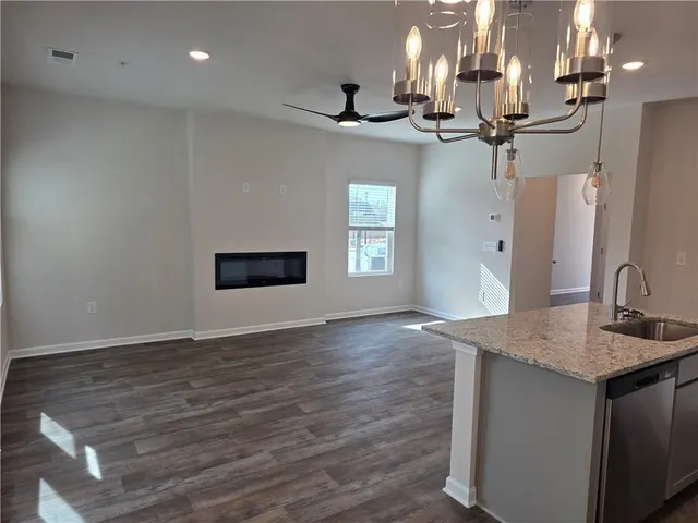 a view of a kitchen with a sink and dishwasher a refrigerator with wooden floor