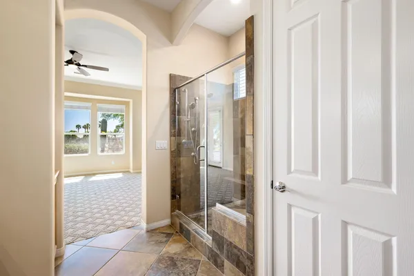 a bathroom with a glass shower door and a glass door