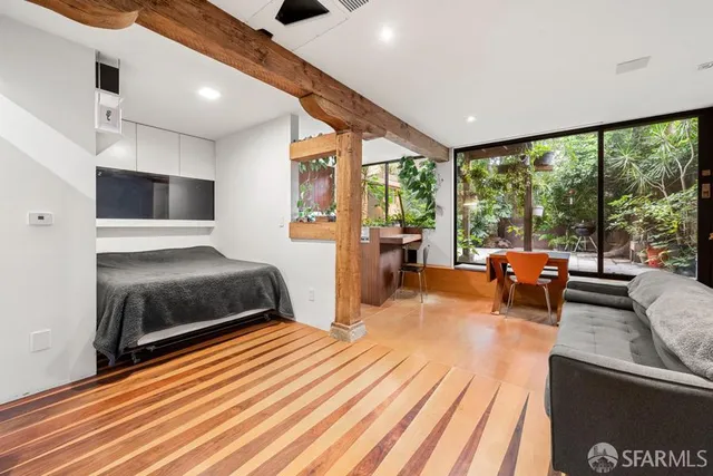 a spacious bedroom with a bed and wooden floor