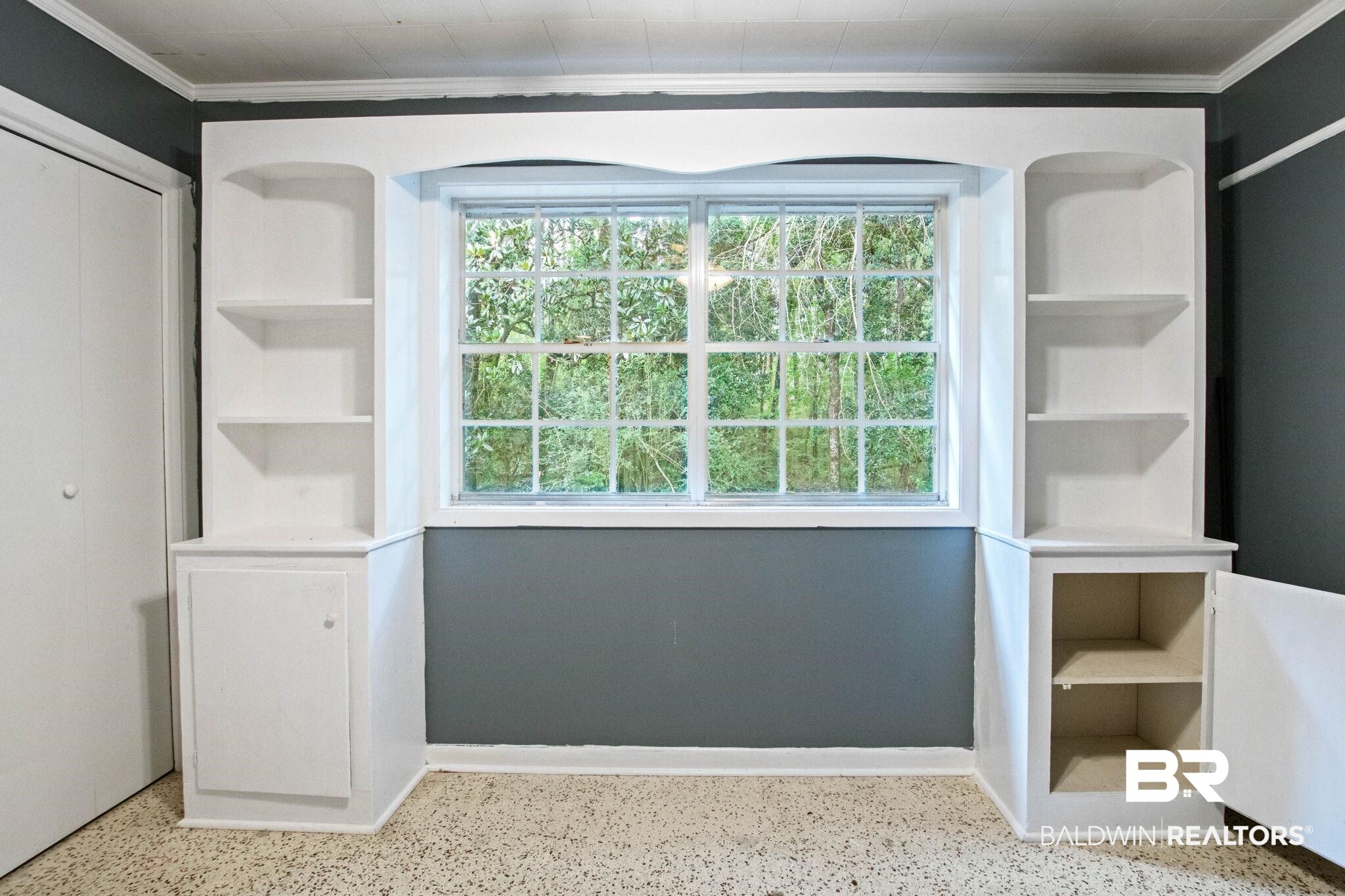 384 Old Bratt Road Atmore, AL 36502 - Photo 43 of 64 Built-in shelving units flank a multi-pane window, featuring arched top shelves and lower cabinet storage