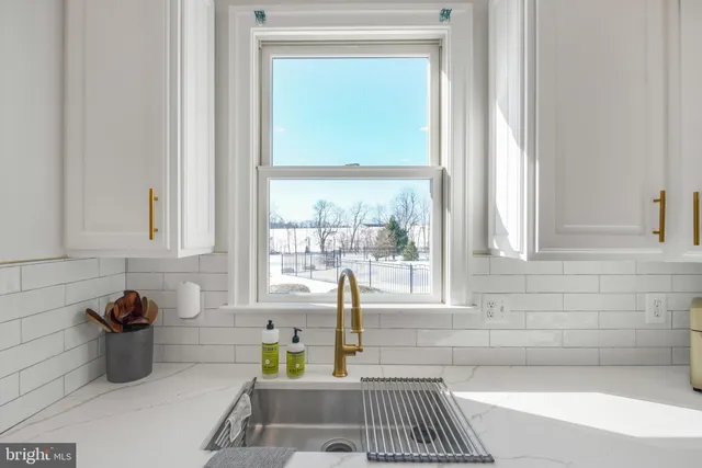 a view of a patio with lawn chairs and couches under an umbrella