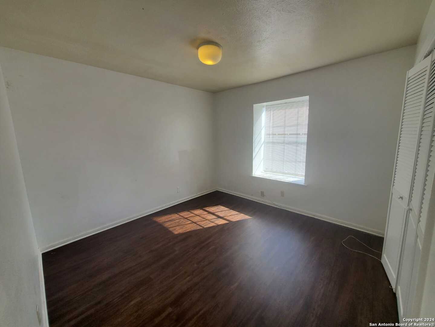 170 De Chantle Road, Unit 208 San Antonio, TX 78201 - Photo 12 of 14 an empty room with wooden floor and windows