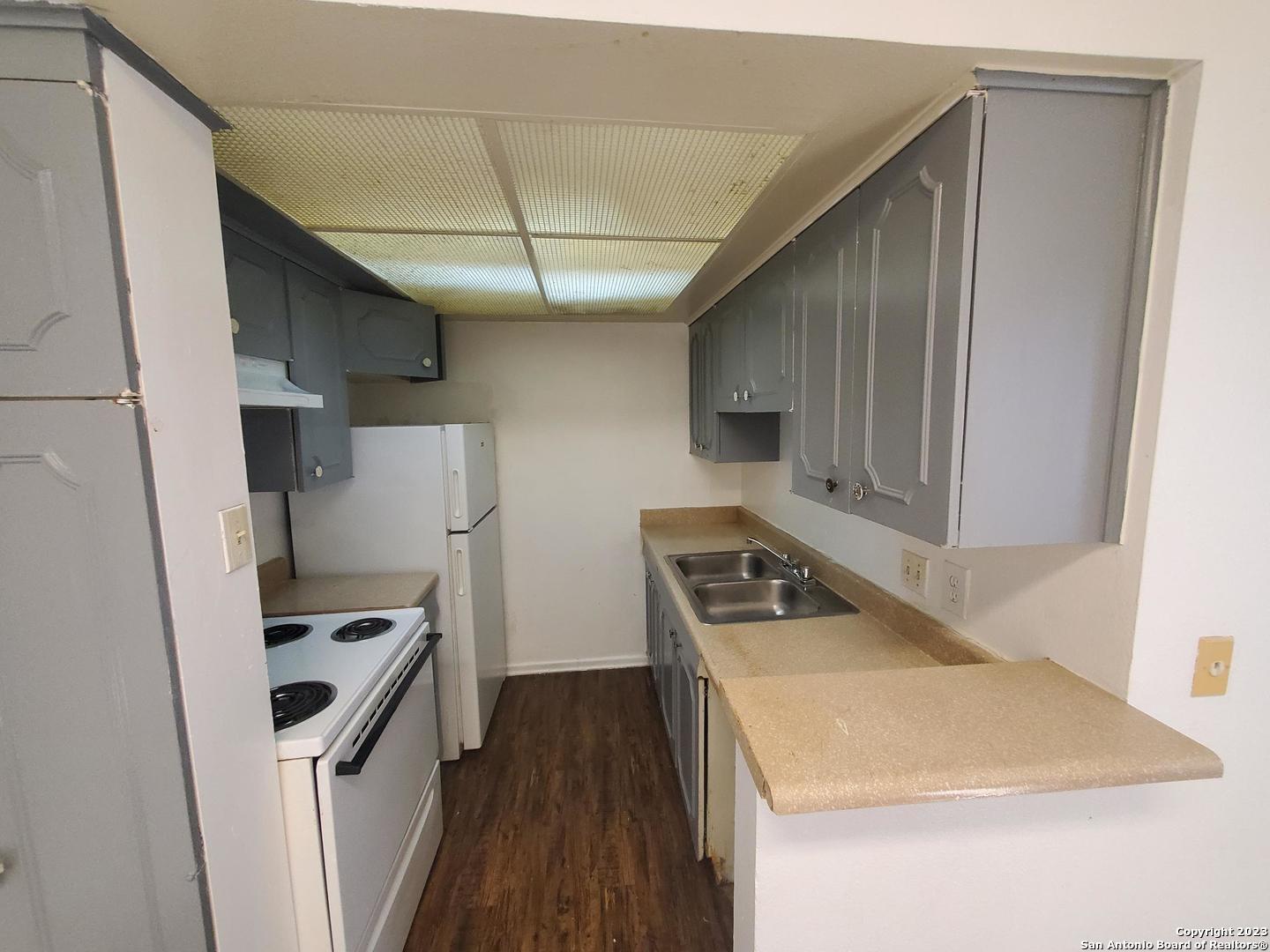 170 De Chantle Road, Unit 208 San Antonio, TX 78201 - Photo 2 of 14 a kitchen that has a sink a refrigerator and a stove