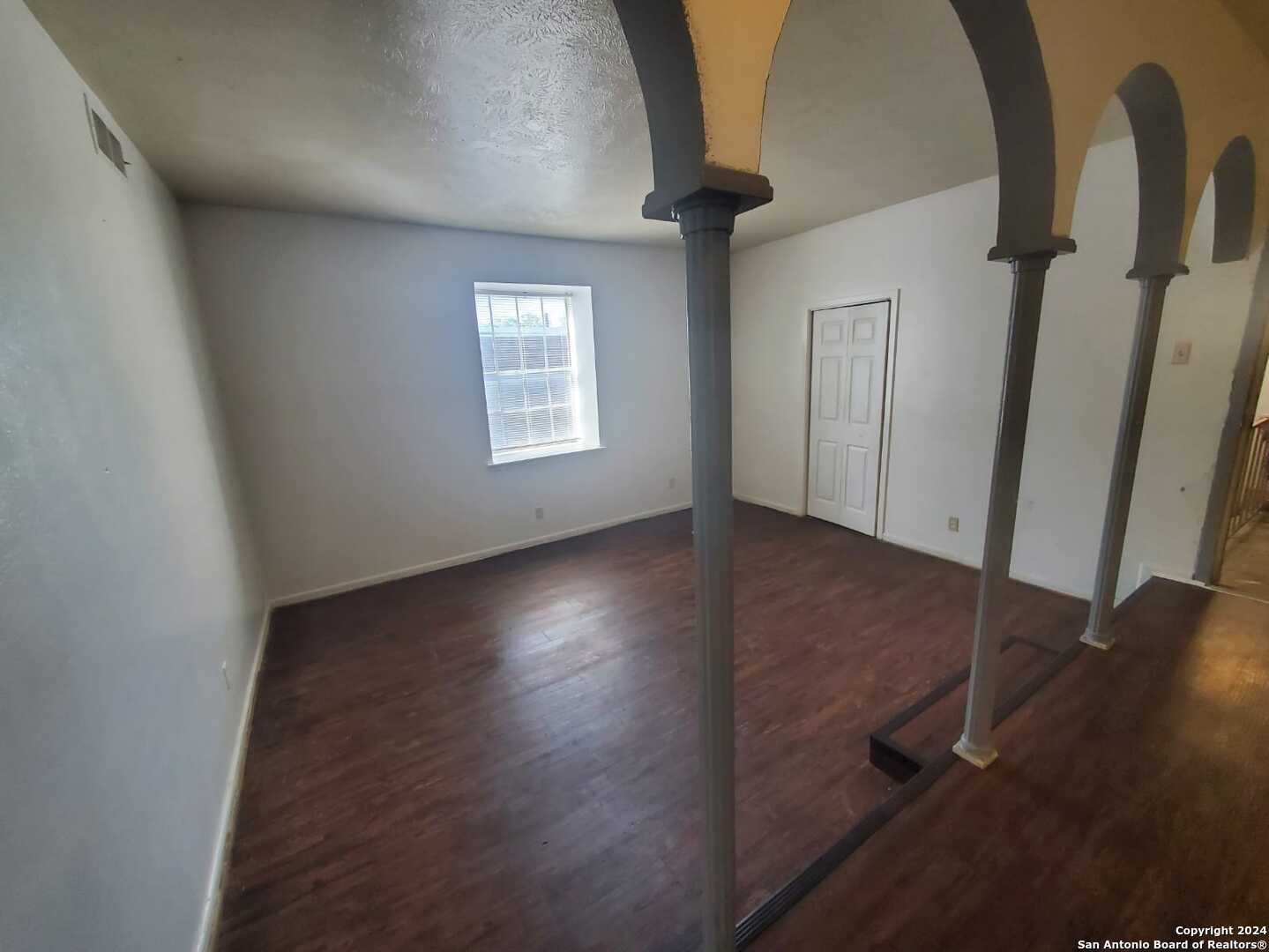 170 De Chantle Road, Unit 208 San Antonio, TX 78201 - Photo 4 of 14 an empty room with wooden floor and windows