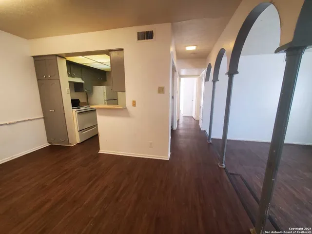a view of a hallway with wooden floor stairs