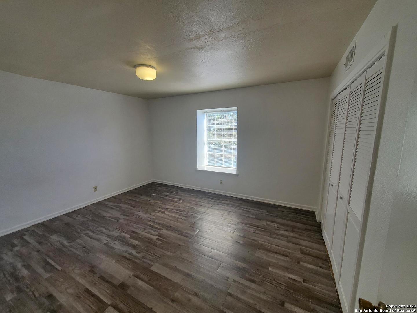 170 De Chantle Road, Unit 208 San Antonio, TX 78201 - Photo 9 of 14 an empty room with wooden floor and windows