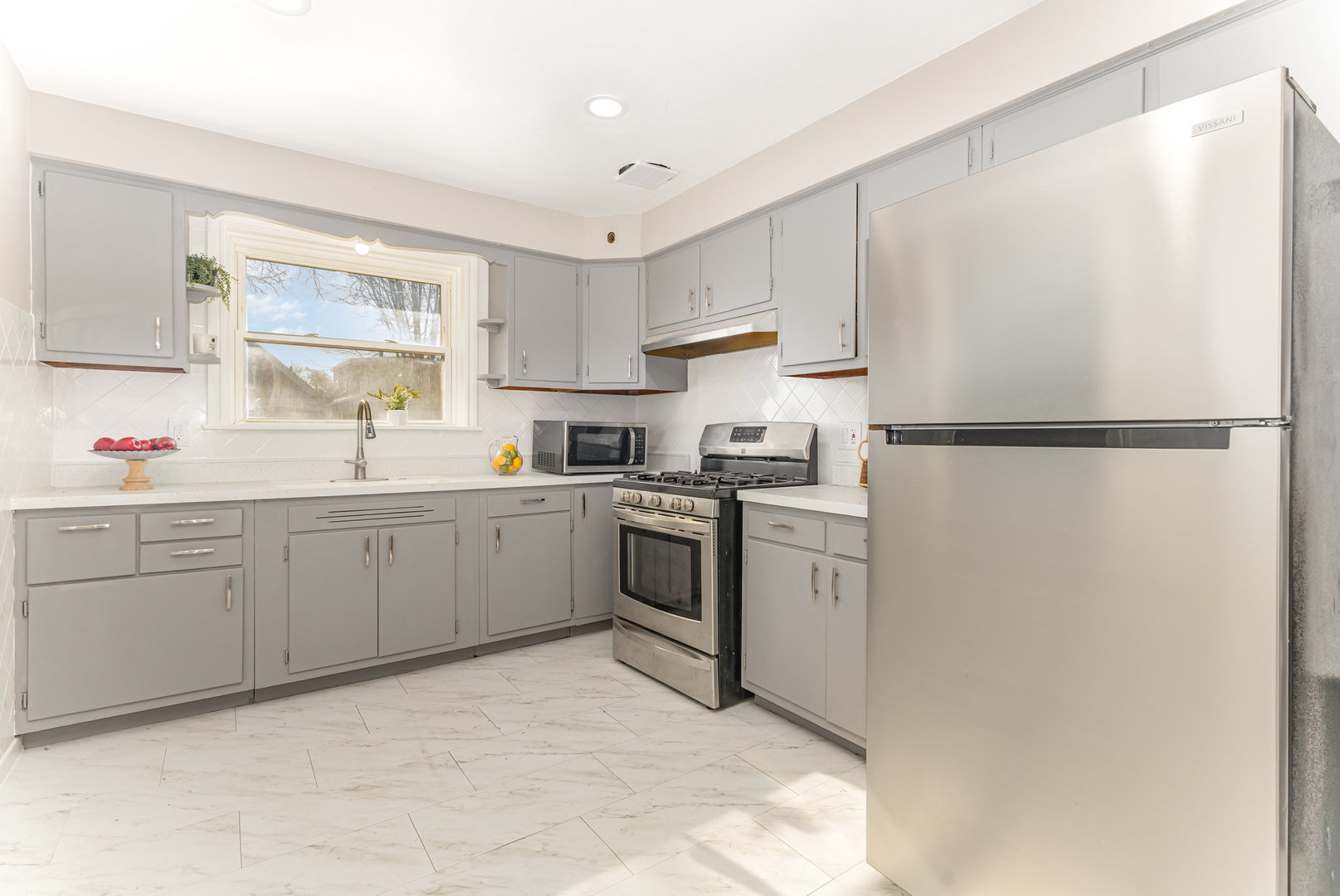 4852 West Hirsch Street Chicago, IL 60651 - Photo 11 of 38 a kitchen with white cabinets white stainless steel appliances and sink