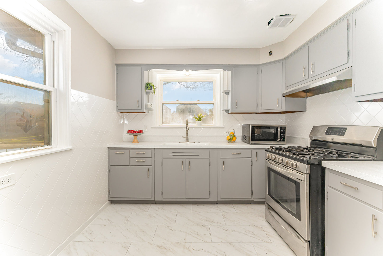 4852 West Hirsch Street Chicago, IL 60651 - Photo 10 of 38 a kitchen with cabinets appliances a sink and a window