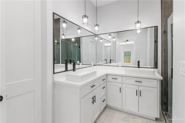 a spacious bathroom with a double vanity sink a mirror and shower