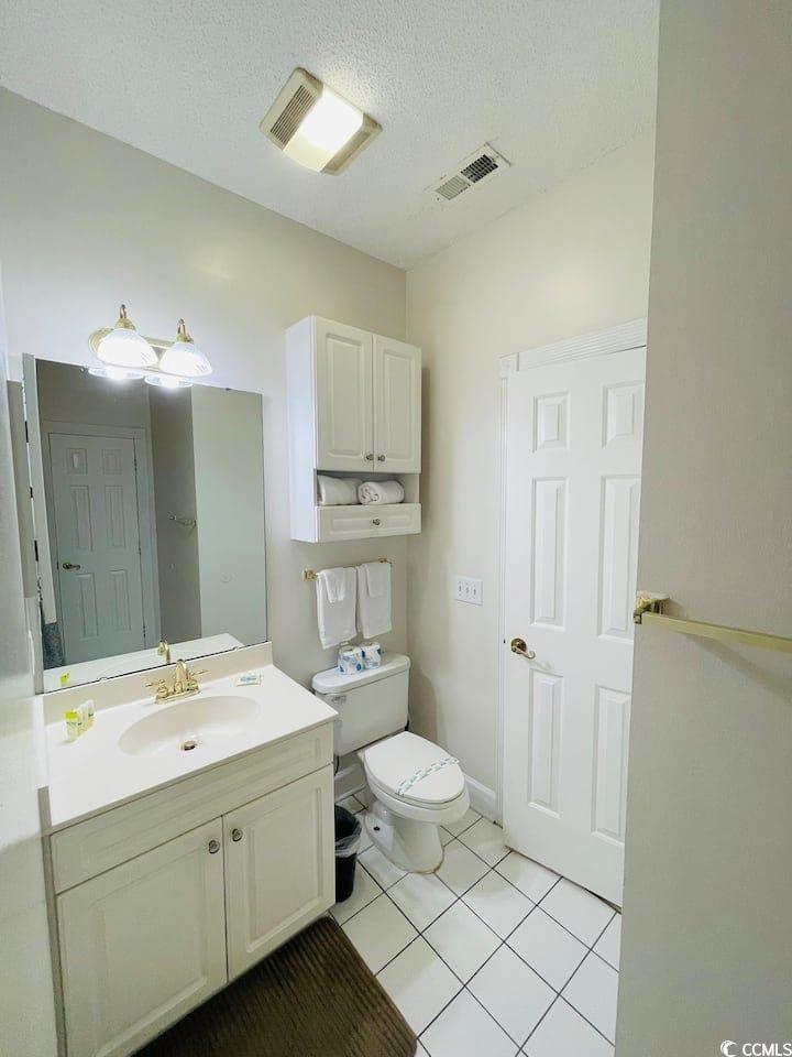 4631 Wild Iris Drive, Unit 301 Myrtle Beach, SC 29577 - Photo 20 of 37 Half bath with vanity, light tile patterned flooring, and a textured ceiling