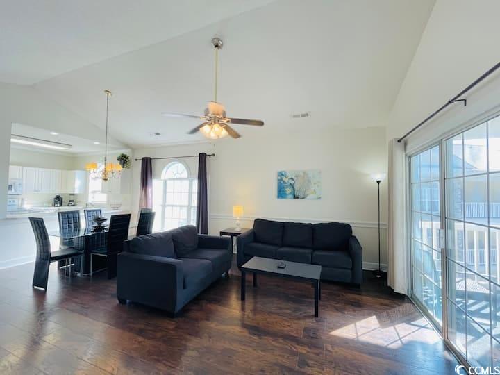 4631 Wild Iris Drive, Unit 301 Myrtle Beach, SC 29577 - Photo 2 of 37 Living room with vaulted ceiling, dark wood-type flooring, ceiling fan, and a chandelier