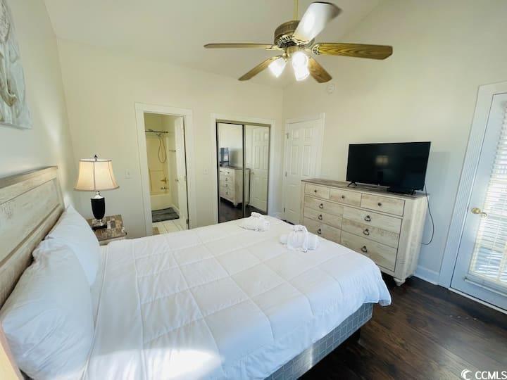 4631 Wild Iris Drive, Unit 301 Myrtle Beach, SC 29577 - Photo 24 of 37 Bedroom with ensuite bathroom, ceiling fan, a closet, and dark wood-style flooring