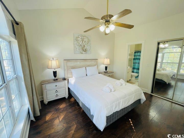 4631 Wild Iris Drive, Unit 301 Myrtle Beach, SC 29577 - Photo 25 of 37 Bedroom with dark wood finished floors, ceiling fan, lofted ceiling, ensuite bath, and a closet