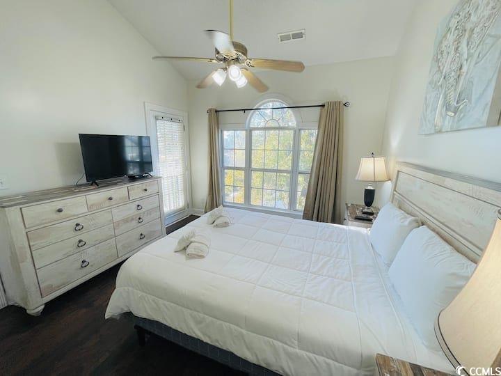 4631 Wild Iris Drive, Unit 301 Myrtle Beach, SC 29577 - Photo 26 of 37 Bedroom featuring vaulted ceiling, a ceiling fan, and dark wood-style floors