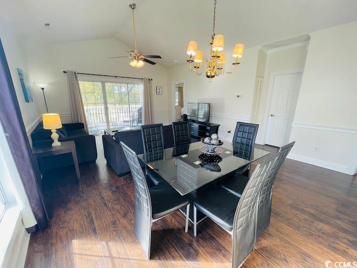 4631 Wild Iris Drive, Unit 301 Myrtle Beach, SC 29577 - Photo 5 of 37 Dining area with dark wood-style flooring, a chandelier, vaulted ceiling, and a ceiling fan