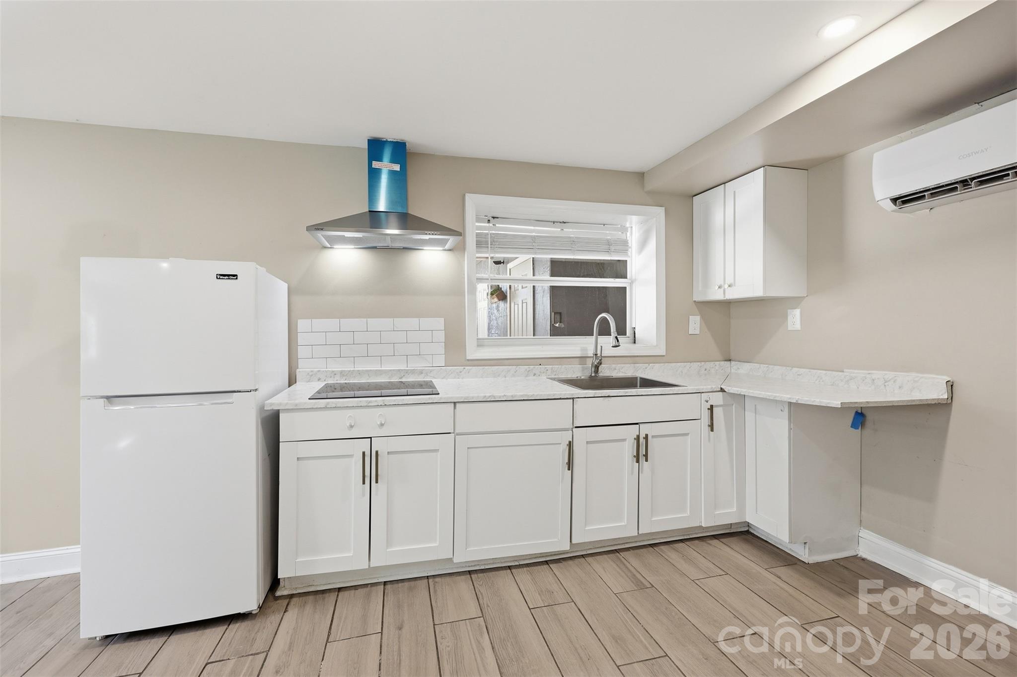 4920 Bright Road Charlotte, NC 28214 - Photo 20 of 46 a kitchen with a sink a refrigerator and white cabinets
