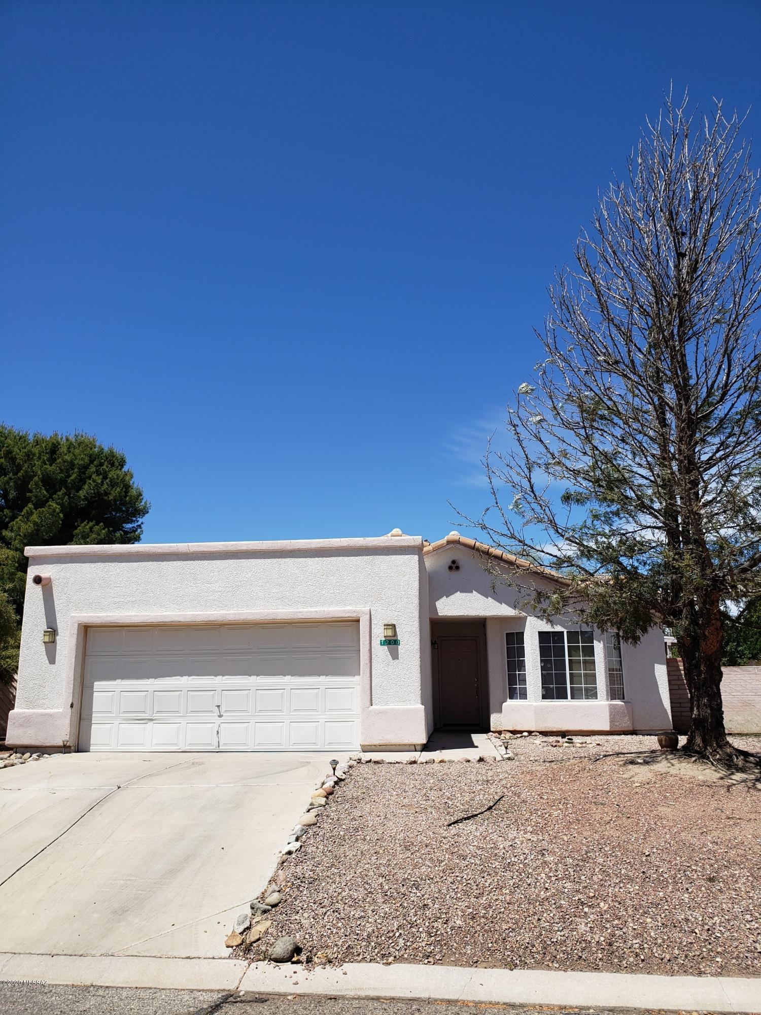 1200 Desert Dawn Drive Rio Rico, AZ 85648 - Photo 2 of 24 a front view of a house with a yard and a garage