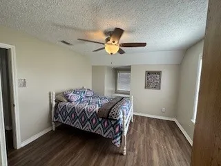 a view of house with backyard and bushes