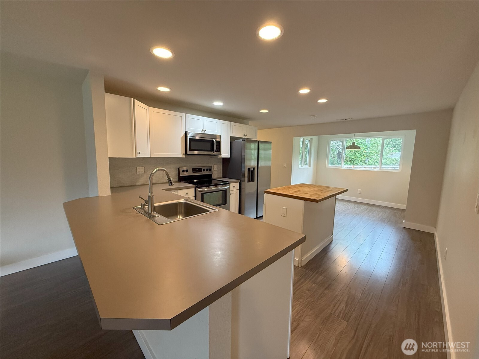 8820 Prentice Avenue Gig Harbor, WA 98332 - Photo 3 of 13 a large kitchen with sink a refrigerator and wooden floor