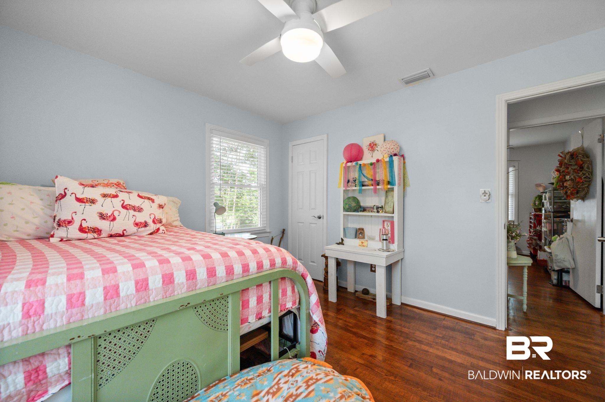 5417 Windmill Drive Mobile, AL 36693 - Photo 18 of 26 Hardwood flooring throughout, featuring a ceiling fan with integrated lighting, a single window with blinds, and white trim molding