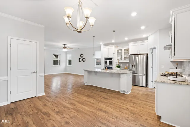 a kitchen with stainless steel appliances granite countertop a refrigerator and a stove top oven
