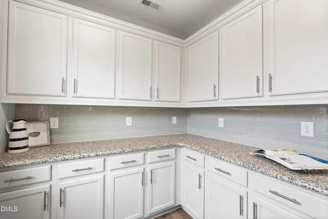 a kitchen with granite countertop white cabinets and a white appliances