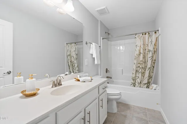 a bathroom with a sink toilet double vanity and shower