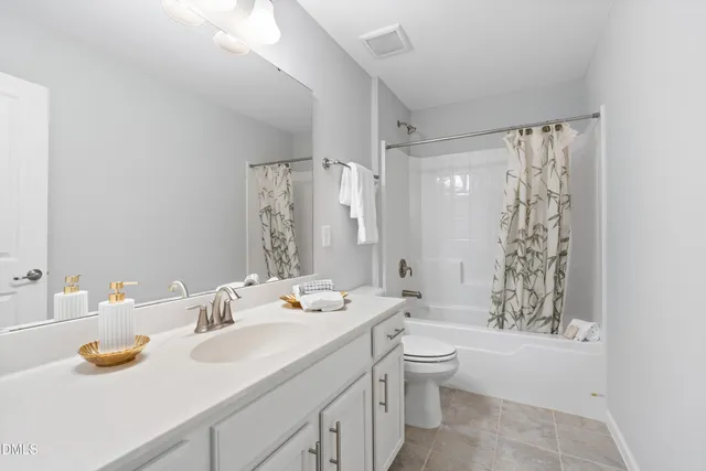 a bathroom with a sink a toilet and shower curtain