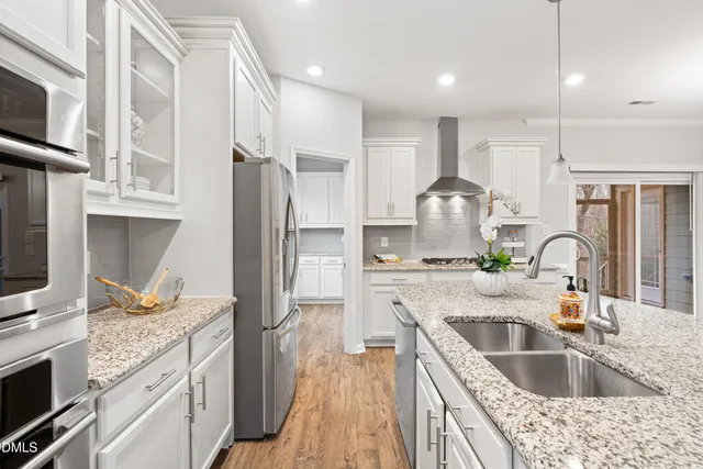 a kitchen with kitchen island granite countertop a sink stainless steel appliances and cabinets