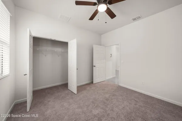 an empty room with closet and windows