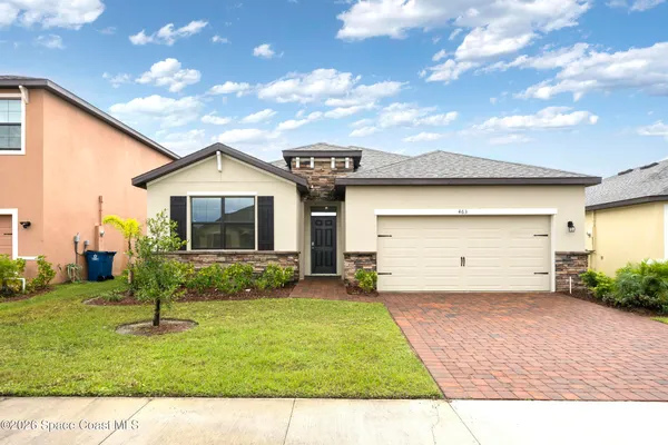 a view of a house with backyard and a tree