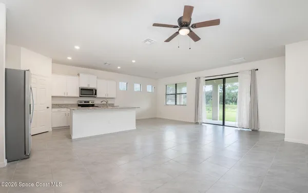 a view of kitchen with microwave a stove and white cabinets