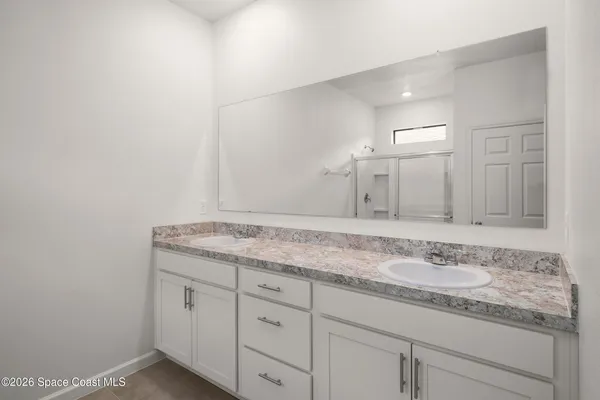 a bathroom with a granite countertop sink and white cabinets