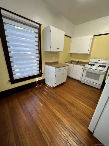 a kitchen with a wooden floor and a stove top oven