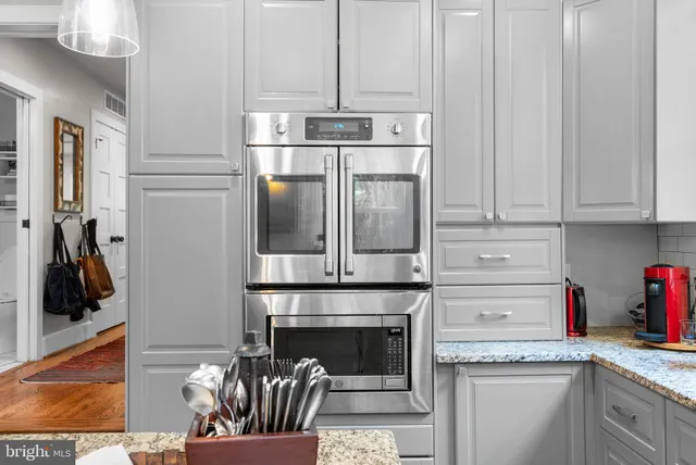 a kitchen with stainless steel appliances granite countertop a refrigerator and a stove top oven
