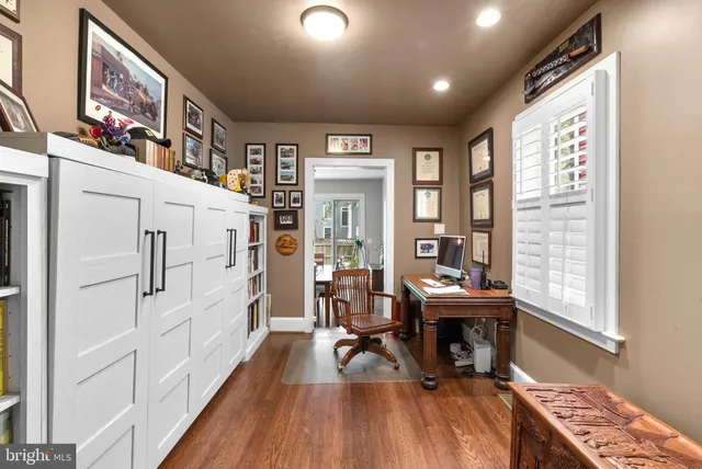 a view of a livingroom with furniture hardwood floor and workspace