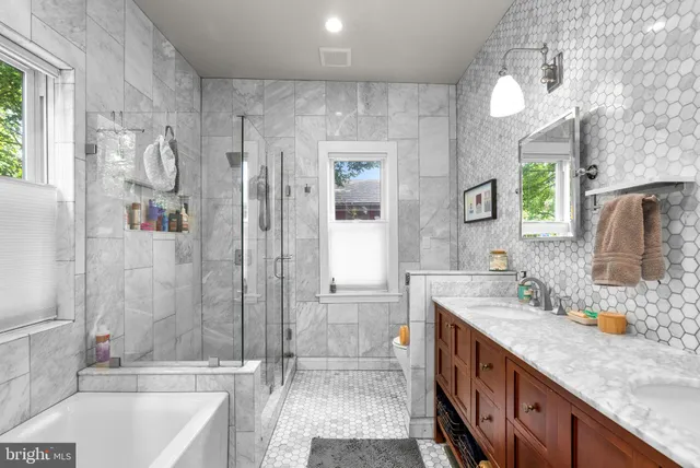 a bathroom with a granite countertop sink mirror and a bathtub