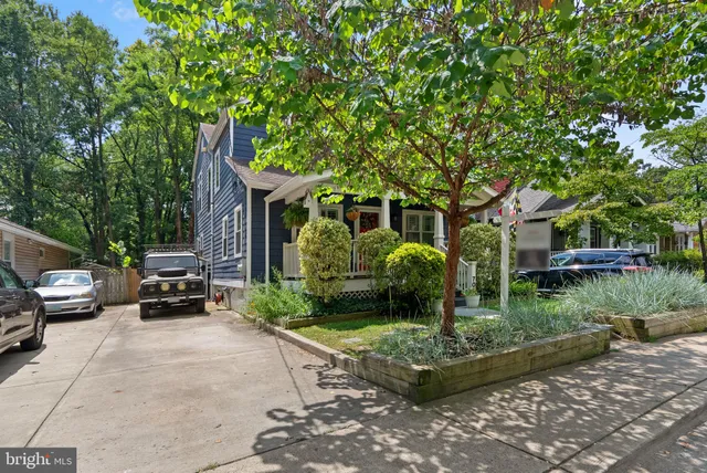a view of a house with a cars park side of a road