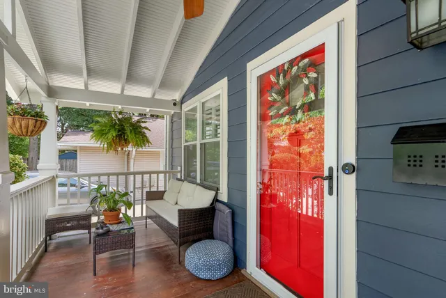 a living room with furniture a floor to ceiling window and wooden floor