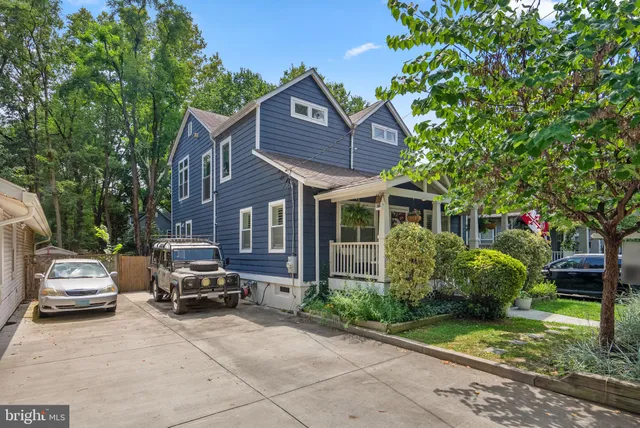 a car parked in front of a house with a garden