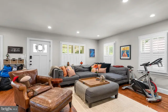 a living room with furniture a flat screen tv and a window
