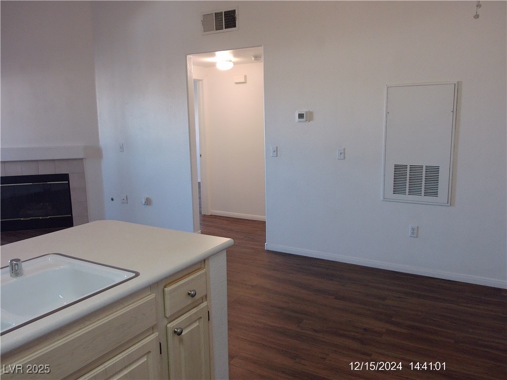 855 North Stephanie Street, Unit 2526 Henderson, NV 89014 - Photo 14 of 26 Kitchen with light countertops, dark wood-type flooring, and a fireplace